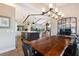 Open-concept dining area boasts a custom wooden table, chandelier, and seamless flow to the kitchen and living areas at 29150 Beauclaire Dr, Tavares, FL 32778