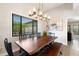 Bright dining room features a wooden table, modern chandelier, and large window with outdoor views at 29150 Beauclaire Dr, Tavares, FL 32778
