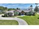 Well-maintained home featuring a circular driveway, mature landscaping, and a welcoming facade at 29150 Beauclaire Dr, Tavares, FL 32778