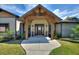Inviting front entrance with wooden beams, double doors, and tasteful landscaping at 29150 Beauclaire Dr, Tavares, FL 32778