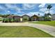 Charming single-story home with a well-manicured lawn, mature landscaping, and a welcoming entrance at 29150 Beauclaire Dr, Tavares, FL 32778