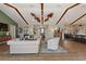 Open concept living room with vaulted wood beam ceilings and view of the dining area and front entryway at 29150 Beauclaire Dr, Tavares, FL 32778