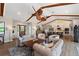 Bright living room with modern ceiling fans, vaulted ceilings, wood beams, and open access to the kitchen at 29150 Beauclaire Dr, Tavares, FL 32778
