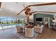 Elegant living space featuring a stone fireplace, vaulted ceiling, and views of the pool and lake at 29150 Beauclaire Dr, Tavares, FL 32778