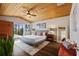 Bright main bedroom boasts wood ceiling with fan, rug, king bed, and sliders to an outdoor lanai at 29150 Beauclaire Dr, Tavares, FL 32778