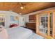 Modern main bedroom with wood ceiling features a sauna, colorful artwork, and bathroom entrance at 29150 Beauclaire Dr, Tavares, FL 32778