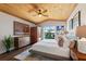 Sunny main bedroom with wood ceiling features sliders to the pool area and wood dresser with modern art at 29150 Beauclaire Dr, Tavares, FL 32778
