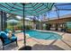 Screened pool area with outdoor seating, lush landscaping, and a peek into the home's interior at 29150 Beauclaire Dr, Tavares, FL 32778