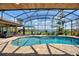 Screened in pool and patio area with comfortable seating, dining, and lush landscaping at 29150 Beauclaire Dr, Tavares, FL 32778