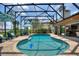 Large screened in pool with outdoor furniture, comfortable seating and lush landscaping at 29150 Beauclaire Dr, Tavares, FL 32778