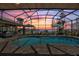 A screened-in pool with lounge chairs and view of the lake during a colorful sunset at 29150 Beauclaire Dr, Tavares, FL 32778