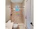 Well-lit bathroom with tiled shower, toilet, and access to the backyard at 30411 Gidran Ter, Mount Dora, FL 32757