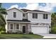 Inviting two-story home featuring stone accents, a covered entryway, and an attached two-car garage at 33432 Seattle Slew Dr, Sorrento, FL 32776