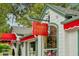 Charming museum exterior with a red awning, bright windows, and lush greenery, creating an inviting atmosphere at 33432 Seattle Slew Dr, Sorrento, FL 32776