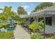 Outdoor dining area at a Mediterranean restaurant with hanging plants, sidewalk, and views of the street and neighborhood at 33432 Seattle Slew Dr, Sorrento, FL 32776