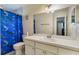 Bathroom with a single sink vanity, large mirror, toilet, and a shower/tub with blue shark curtain at 4366 Roanne Dr, Orlando, FL 32817