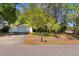 Front of home featuring a two-car garage, brick accents, mature trees and landscaping at 4366 Roanne Dr, Orlando, FL 32817