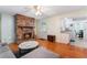 Open living space with wood laminate flooring, fireplace, and view of the eat-in kitchen at 4366 Roanne Dr, Orlando, FL 32817