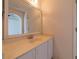 Bathroom featuring white cabinets, neutral countertop, and large mirror at 458 Cadenza Dr, Orlando, FL 32807