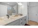 Bathroom featuring a dual sink vanity with quartz countertop, modern fixtures, and a large mirror at 4630 Cragmere Loop, Clermont, FL 34711