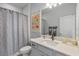 Well-lit bathroom featuring a vanity with modern fixtures, a shower with a curtain, and neutral color palette at 4630 Cragmere Loop, Clermont, FL 34711