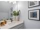 A stylish bathroom showcases modern fixtures, an elegant sink, and framed artwork enhancing the space at 4630 Cragmere Loop, Clermont, FL 34711