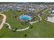 An aerial view captures a luxurious community pool nestled among lush greenery and manicured paths at 4630 Cragmere Loop, Clermont, FL 34711