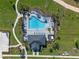 An aerial perspective displays a community pool surrounded by lush landscaping and lounge chairs under palm trees at 4630 Cragmere Loop, Clermont, FL 34711