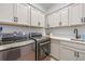 Well-organized laundry room with gray cabinetry, modern appliances, countertop, and sink for added convenience at 4630 Cragmere Loop, Clermont, FL 34711