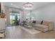 Cozy living room with tile flooring, a comfortable sofa, and sliding doors to the patio at 4630 Cragmere Loop, Clermont, FL 34711