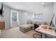 A welcoming bonus room featuring a comfortable gray couch, an ergonomic workspace, and an abundance of natural light at 4630 Cragmere Loop, Clermont, FL 34711