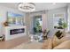 Bright living room featuring a modern fireplace, stylish light fixture, and sliding glass doors to the outdoors at 4630 Cragmere Loop, Clermont, FL 34711