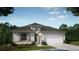 Charming single-story home featuring a two-car garage, neutral color palette, and well-maintained landscaping at 4895 Lyric Dr, Mascotte, FL 34753