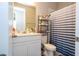 Bathroom featuring a white vanity, mirror, toilet and tub with blue and white striped shower curtain at 4994 Citrus Leaf Blvd, Winter Garden, FL 34787