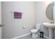 Bathroom featuring a pedestal sink, toilet, and decorative mirror, offering a clean and functional space at 4994 Citrus Leaf Blvd, Winter Garden, FL 34787
