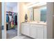 Bathroom view shows a dual sink vanity, a full closet and neutral tile flooring at 4994 Citrus Leaf Blvd, Winter Garden, FL 34787