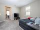 Comfortable bedroom featuring soft carpet, a window letting in natural light and a nice entertainment center with television at 4994 Citrus Leaf Blvd, Winter Garden, FL 34787