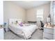This bedroom has a window, white trim, neutral walls and carpet and a comfy bed at 4994 Citrus Leaf Blvd, Winter Garden, FL 34787