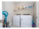 Bright laundry area features modern washer and dryer, shelving and tile flooring at 4994 Citrus Leaf Blvd, Winter Garden, FL 34787