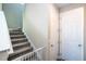 Carpeted staircase with safety gate leading to the upper level with an adjacent door at 4994 Citrus Leaf Blvd, Winter Garden, FL 34787