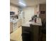 Well lit kitchen includes a breakfast bar, white appliances, and light wood cabinets at 5471 Vineland Rd # 7108, Orlando, FL 32811
