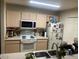 Well lit kitchen includes white appliances, and light wood cabinets, and stainless steel sink at 5471 Vineland Rd # 7108, Orlando, FL 32811