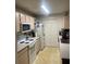 Well lit kitchen includes white appliances, and light wood cabinets, and tile flooring at 5471 Vineland Rd # 7108, Orlando, FL 32811