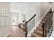 Light-filled entryway featuring wood floors, console table, and a staircase with a dark metal railing at 5610 Wood Bridge Pl, St Cloud, FL 34771