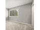 A comfortable bedroom featuring neutral paint, plush carpeting, and a large window at 6114 Peregrine Ave # D03, Orlando, FL 32819