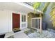 A cozy front entryway welcomes you with a brick-red door and tropical landscaping at 6114 Peregrine Ave # D03, Orlando, FL 32819