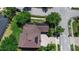 Aerial view of home with a well-manicured lawn, mature trees and solar panels on the roof at 7299 Vista Park Blvd, Orlando, FL 32829
