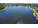 Expansive aerial view of a serene lake surrounded by lush green spaces and homes at 7299 Vista Park Blvd, Orlando, FL 32829