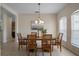 Dining room with wood table, decorative chandelier, and view into the kitchen, features tile flooring at 7299 Vista Park Blvd, Orlando, FL 32829