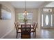 A dining room features tile flooring, a wood table with seating for six, chandelier, and natural light through the windows at 7299 Vista Park Blvd, Orlando, FL 32829